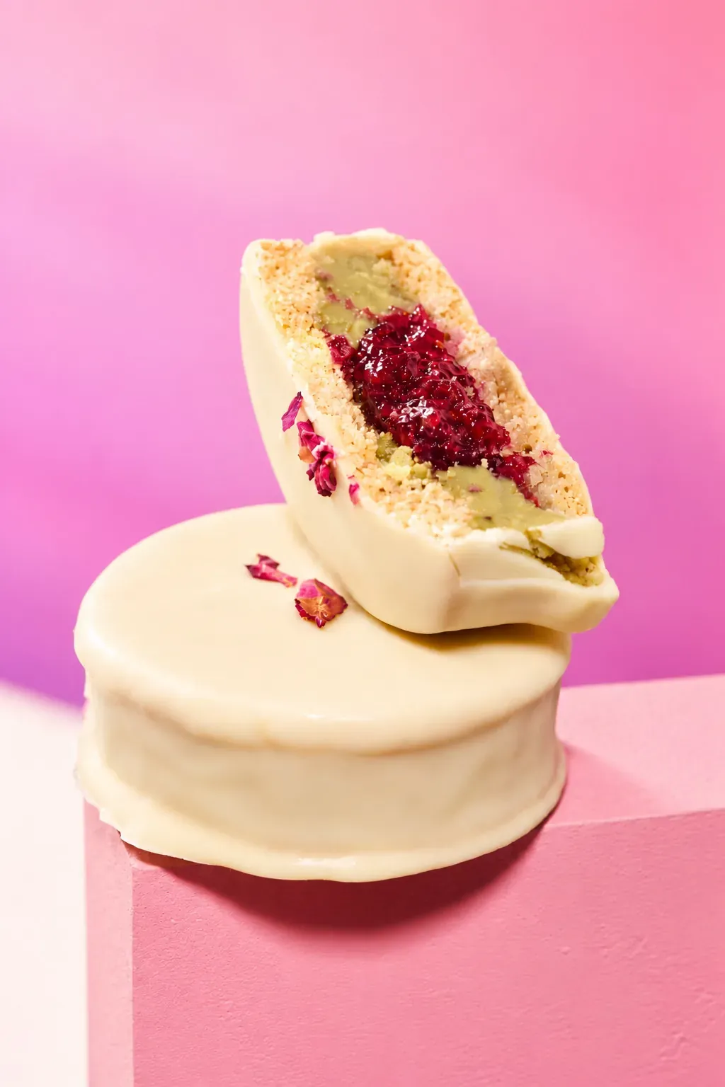 Alfajor de Pistacho y Frambuesa cortado sobre una rejilla
