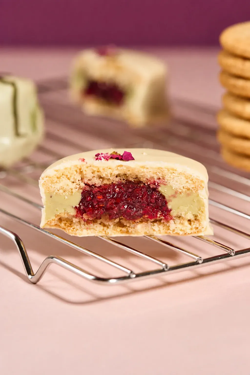Alfajor de Pistacho y Frambuesa cortado sobre una rejilla